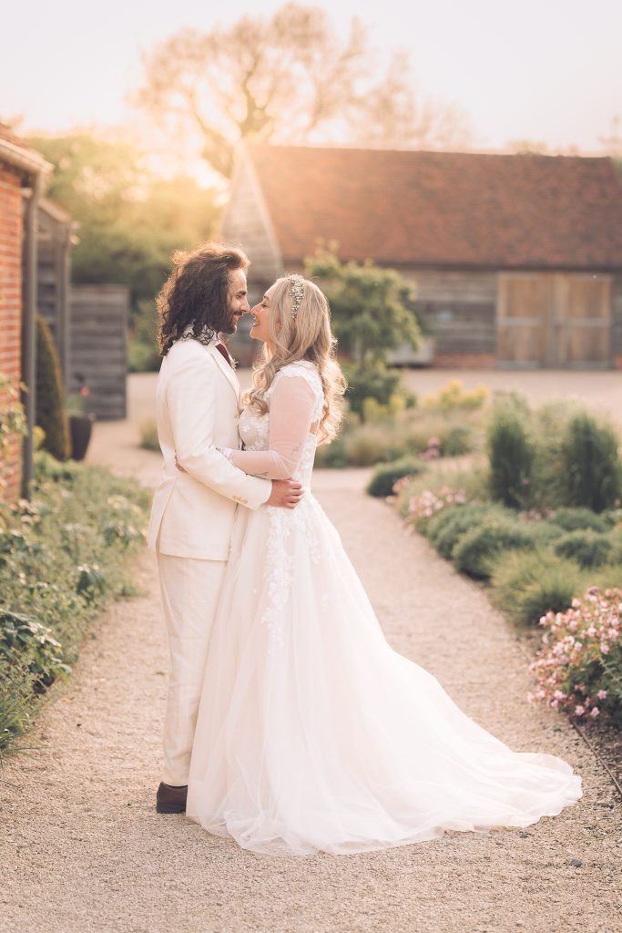 Bride and Groom at sunset in Rackley's Barn. Bride wearing an Ellie Sanderson Gown